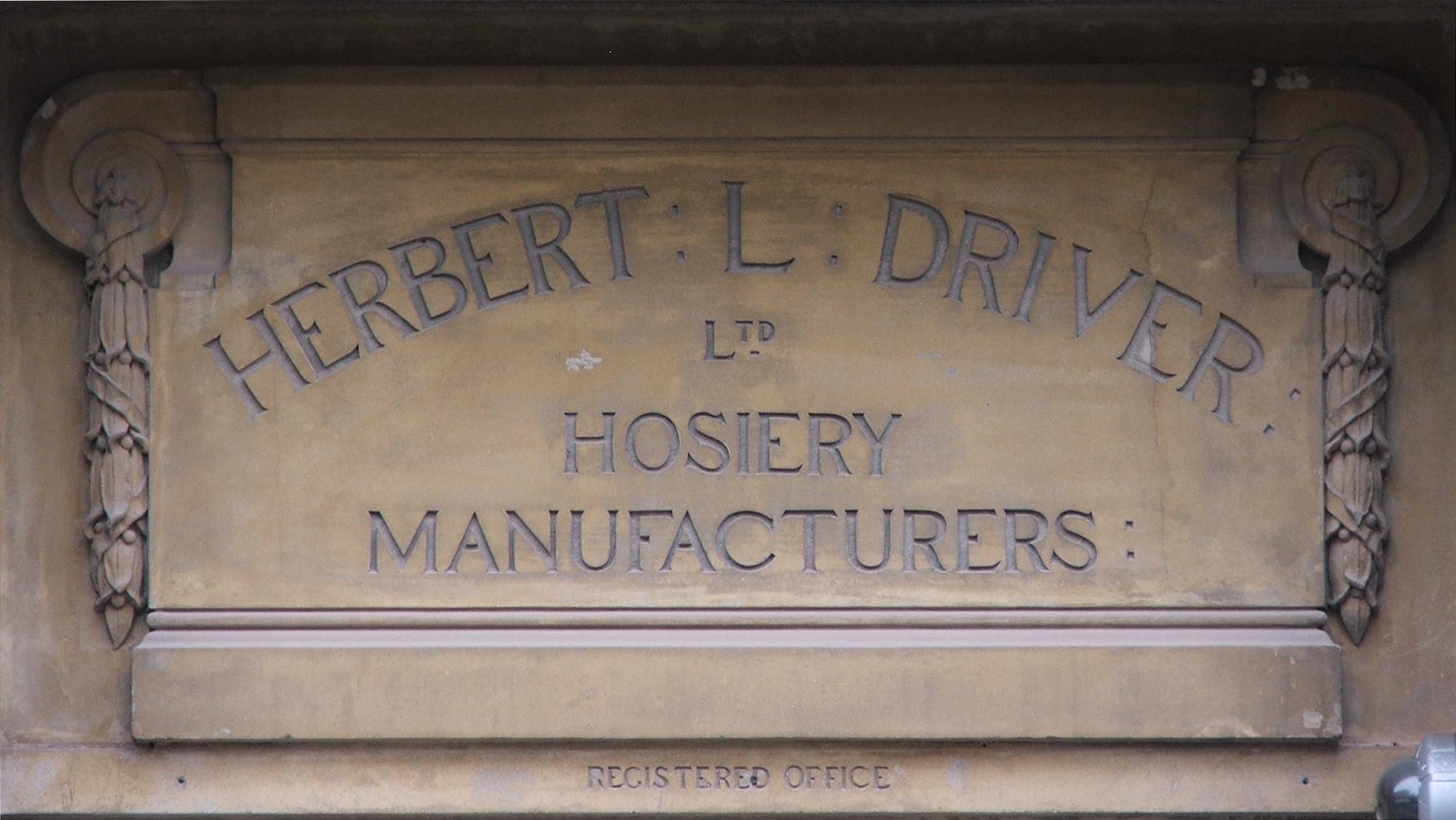 A carved sign for Herbert L.Driver Hosiery Manufactures Ltd. on King Street - Colin Hyde
