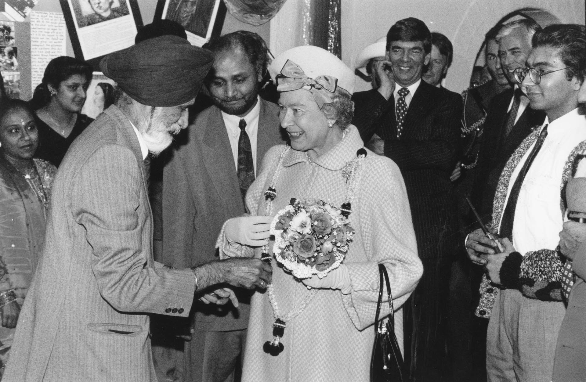 Mr Gurmer Singh presents The Queen with a garland at the Avalon Community project, watched by Mr Mahendra Solanki, head of the project, 1993 - Picture Courtesy Leicester Mercury