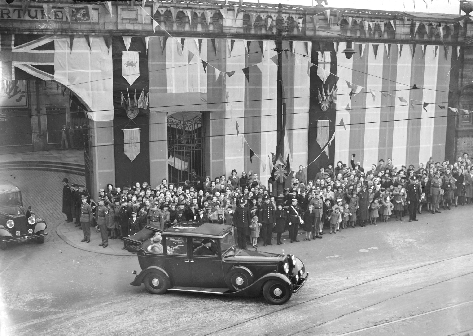 King George VI and Queen Elizabeth leaving Leicester Railway Station, which had been dressed for the occasion, 1944. - Leicestershire Record Office